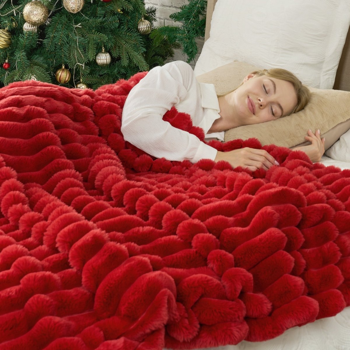 Woman lying on bed with a red fluffy blanket. #color_Christmas Red