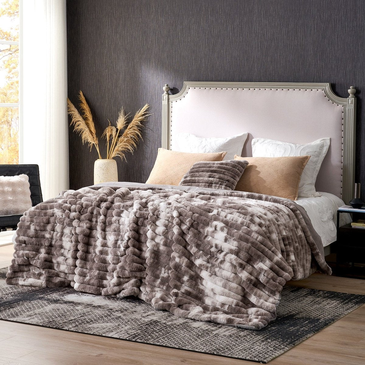 Bedroom with a bed featuring a textured taupe blanket, beige pillows, and a gray headboard. #color_Tie-dye Taupe