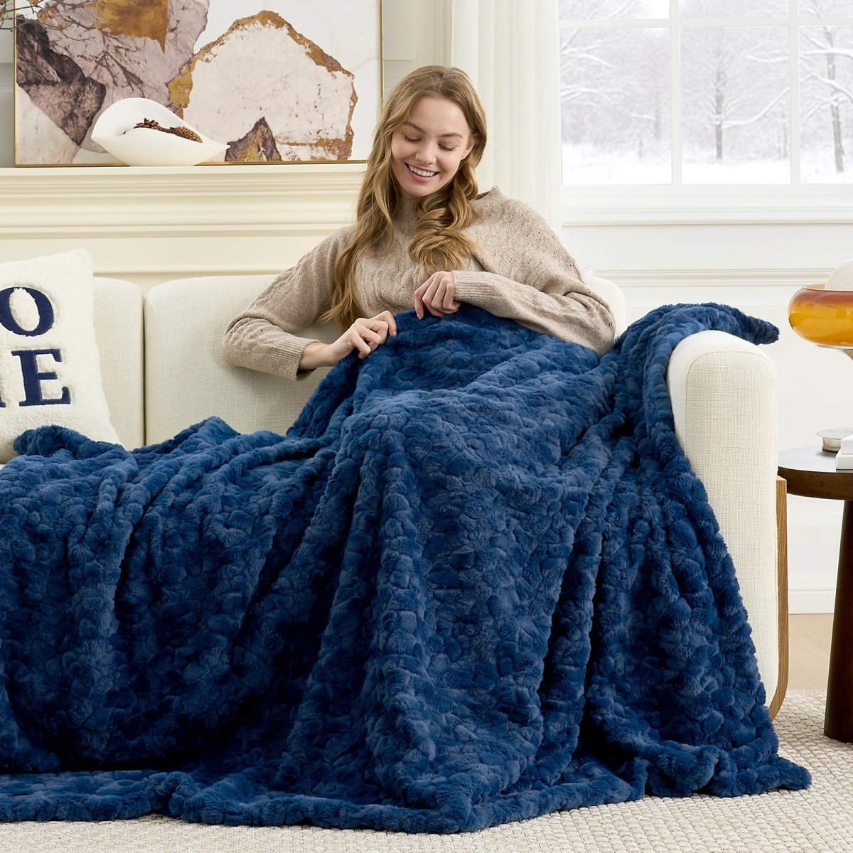Cozy Bliss premium faux fur throw blanket styled across a sofa with a cozy winter atmosphere #color_Navy Blue